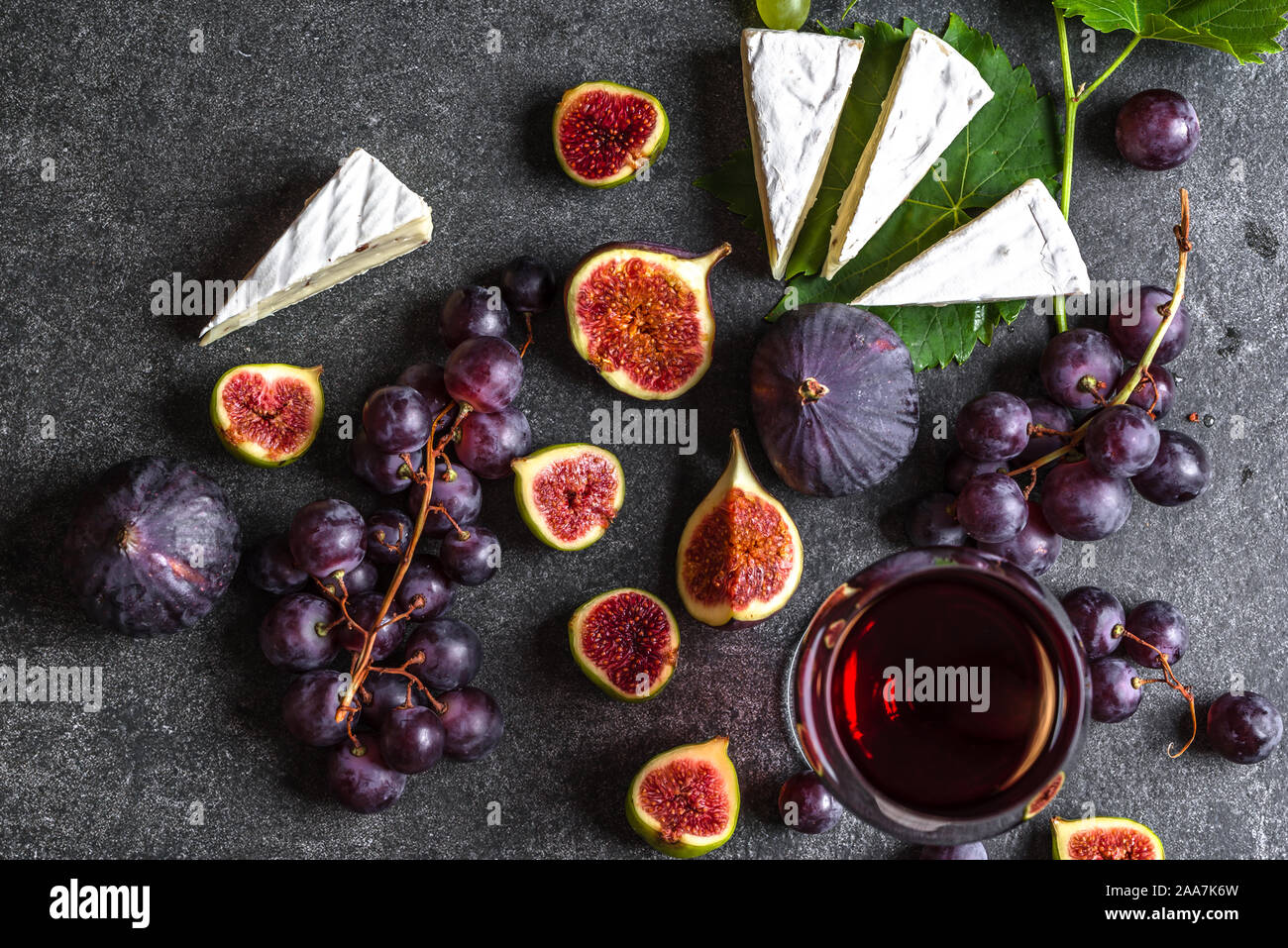 Bicchiere di vino rosso con formaggio, fichi e uva Foto Stock