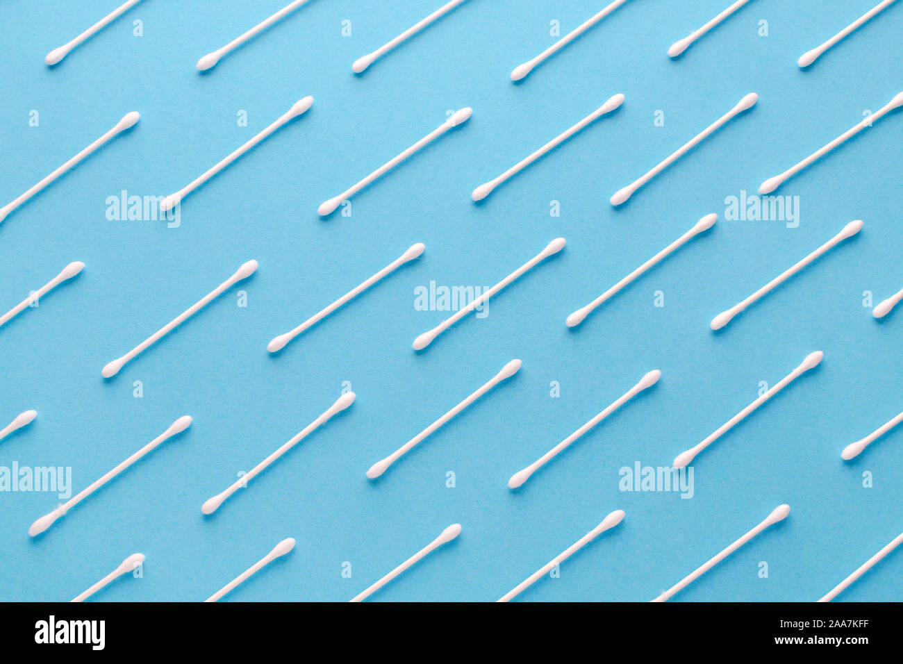 Cotone bianco di bastoni di carta su sfondo blu, modello diagonale Foto Stock