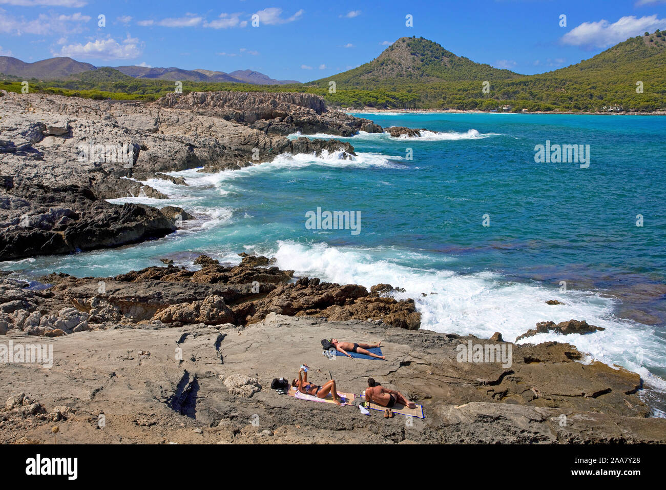 Persone presso la costa rocciosa a Cala Agulla, Cala Ratjada, Maiorca, isole Baleari, Spagna Foto Stock