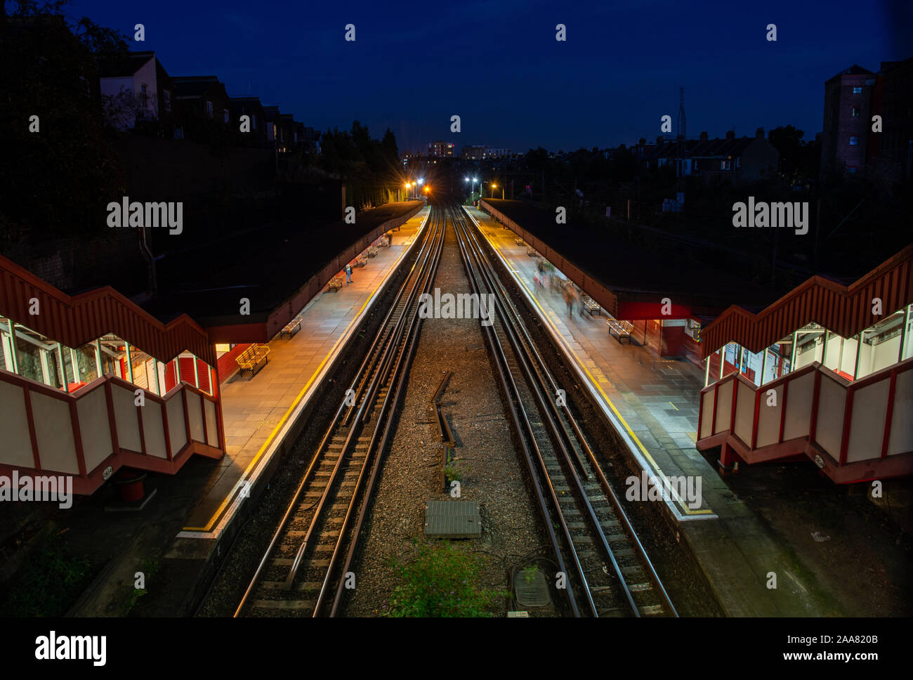 London, England, Regno Unito - 14 Settembre 2019: i passeggeri a piedi lungo le piattaforme a Kensal Green Station nel nord di Londra di notte. Foto Stock