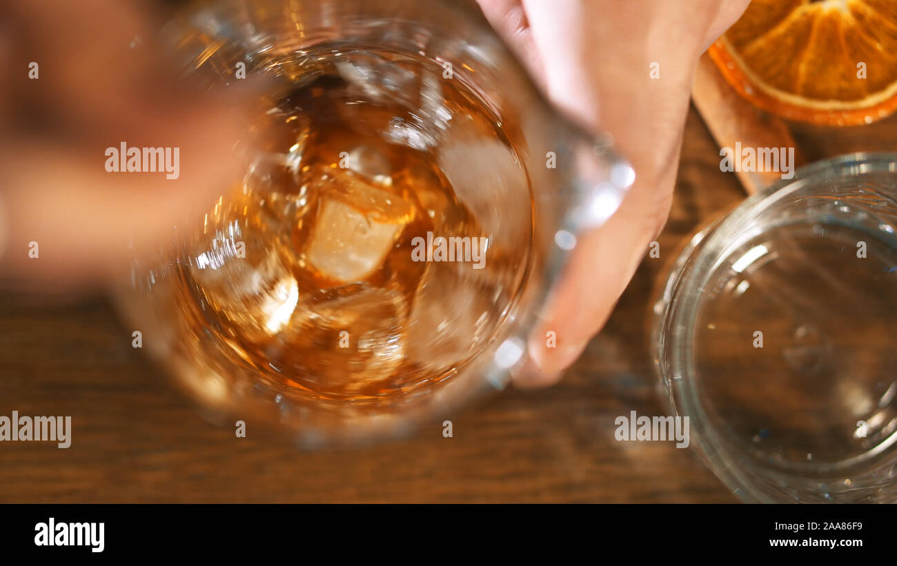 Extra di close-up di un bicchiere in un bar. Il barista mette il ghiaccio e suscita un cocktail alcoolico. Foto Stock Extra di close-up di un bicchiere in un bar. Il barista mette il ghiaccio e suscita un cocktail alcoolico. Foto Stock