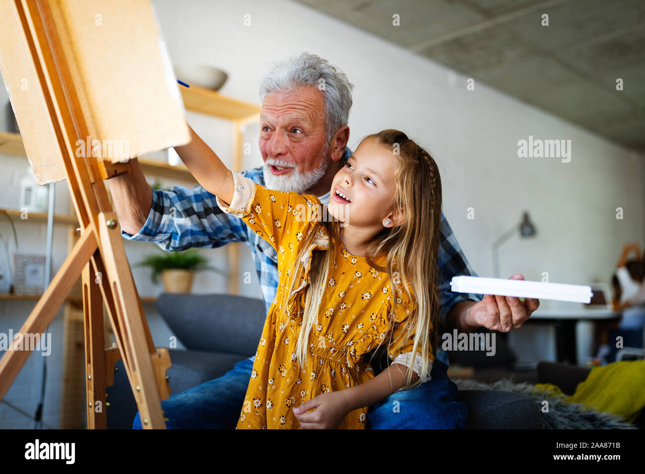 Senior uomo con bambino dipinto su tela. Nonno spendere tempo felice con il nipote. Foto Stock