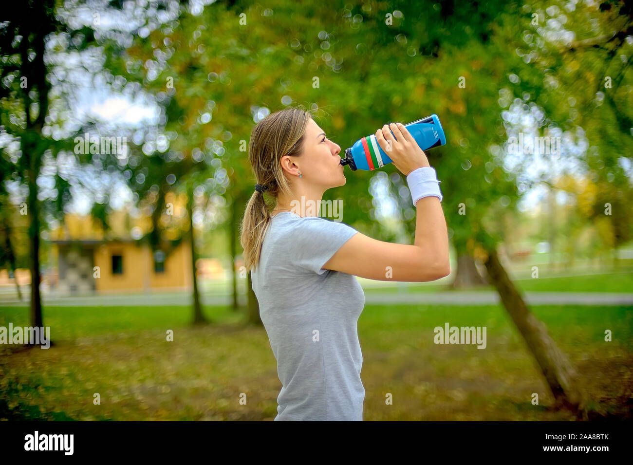 Ragazza atleta è la formazione all'esterno. Bevande Acqua e riposa dopo il jogging. Uno stile di vita sano. Foto Stock