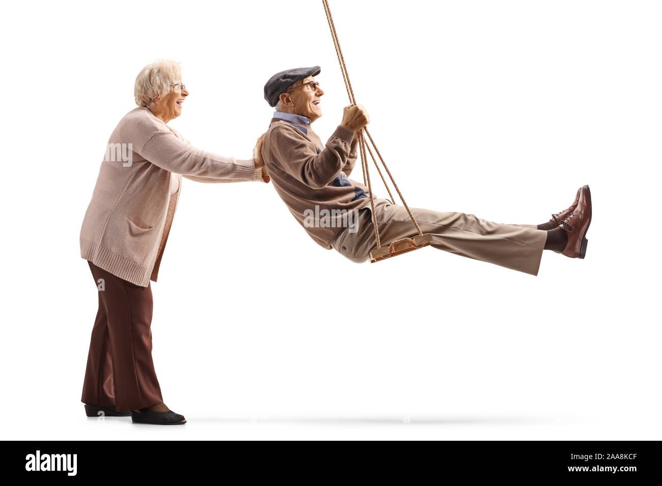 Lunghezza piena ripresa del profilo di una donna senior spingendo oscillazione un anziano uomo su una oscillazione in legno isolato su sfondo bianco Foto Stock