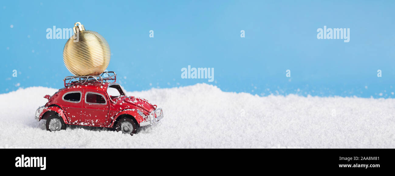 Red vintage giocattolo auto Volkswagen maggiolino con golden palla di Natale sul tetto Foto Stock