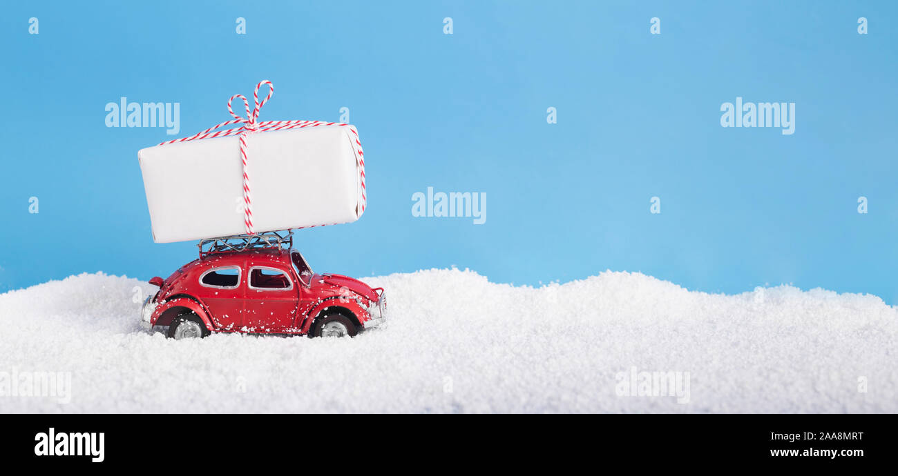 Vintage giocattolo auto Volkswagen maggiolino con confezione regalo sul tetto guida su derive di neve Foto Stock