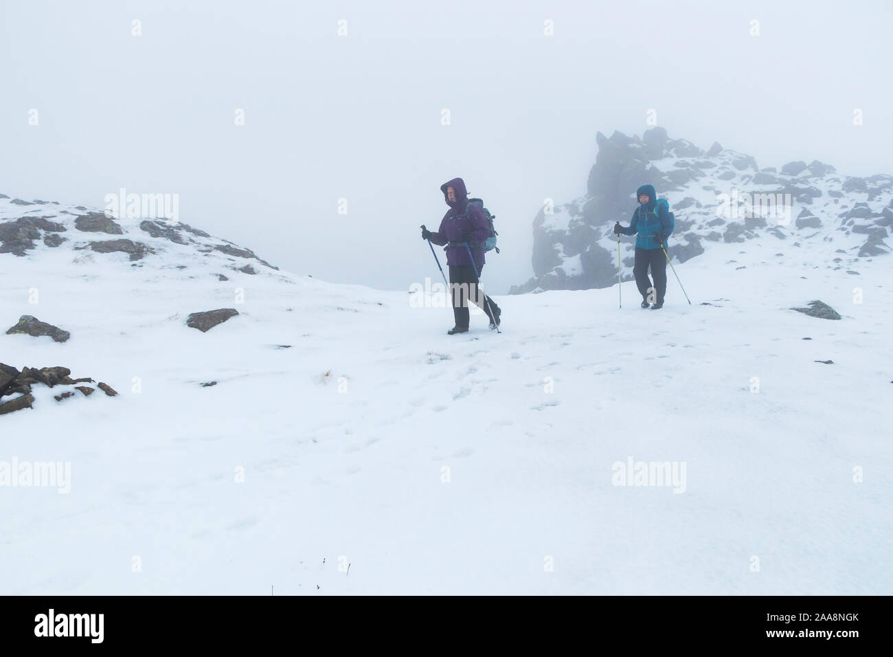 Due escursionisti in condizioni di tempo di inverno sulla montagna del pilastro, Lake District, Cumbria, Regno Unito Foto Stock