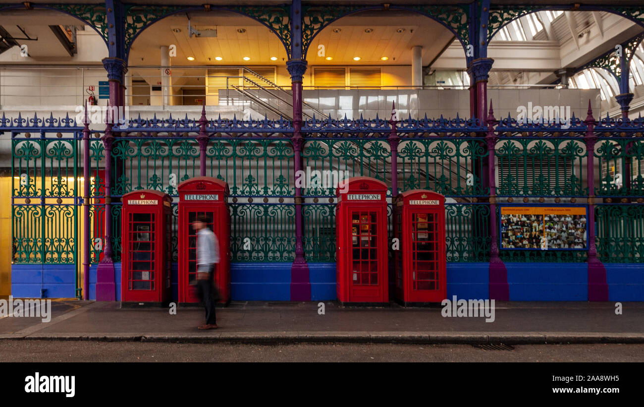 London, England, Regno Unito - 22 Luglio 2010: Un uomo cammina tradizionale del passato telefono rosso scatole in Smithfield Market a Londra. Foto Stock