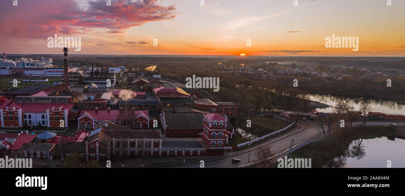 Panorama con vista dal di sopra su un area industriale con un mulino di carta al tramonto nel tardo autunno Foto Stock