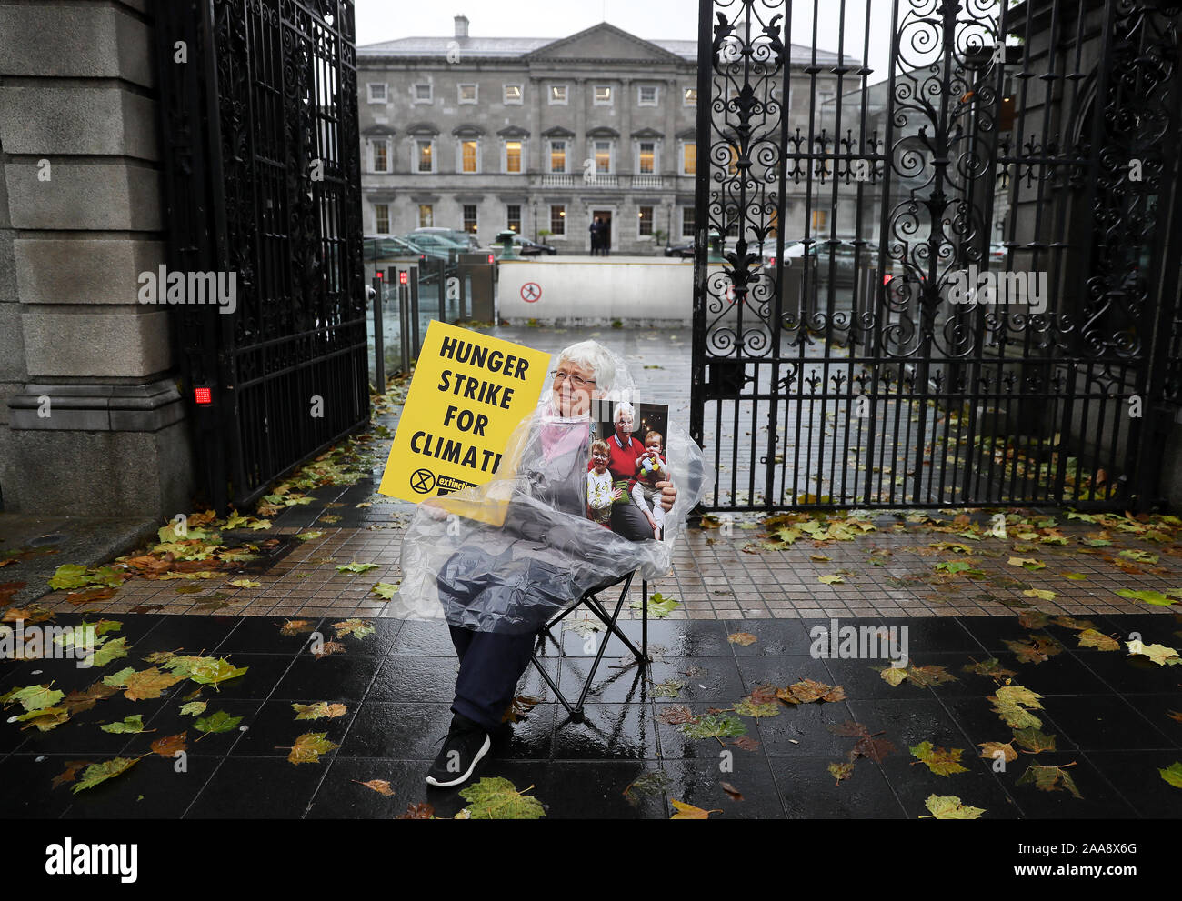 Nonna Patricia Devlin, 78, un membro di estinzione della ribellione in Irlanda, detiene una fotografia dei suoi nipoti Ollie Doyle, 4, e suo fratello Liam, 11 mesi come lei comincia uno sciopero della fame fuori dalle porte di Leinster House, Dublino, per evidenziare il cambiamento climatico. Foto Stock