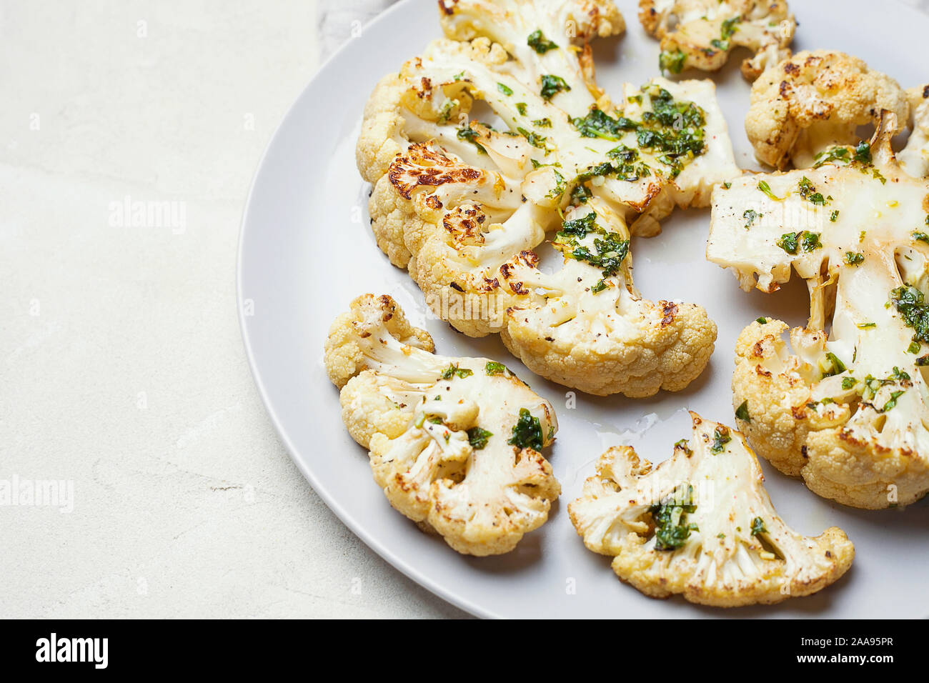 Cavolfiore vegetariano bistecche con il coriandolo lime salsa chimichurri su sfondo bianco con spazio copia.Impianto basato sostituto della carne concetto Foto Stock