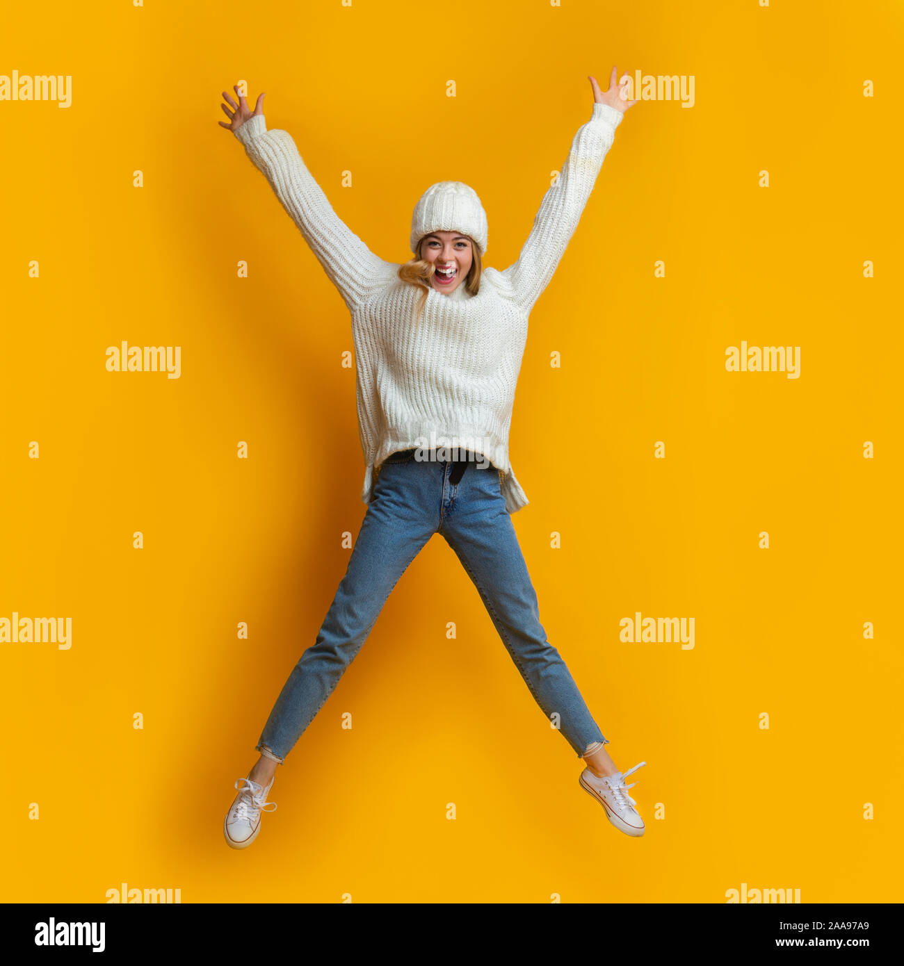 Felice donna bionda jumping come una stella Foto Stock