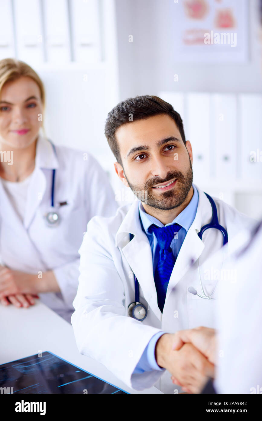 Giovane medico arabo scuote le mani con un collega Foto Stock