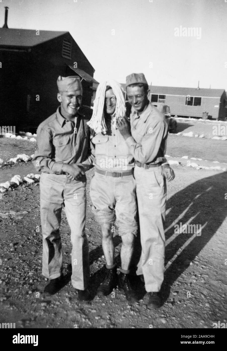 Noi due marinai della marina posano con "donna bionda' mentre stazionava su Guam durante la Seconda Guerra Mondiale. Foto Stock