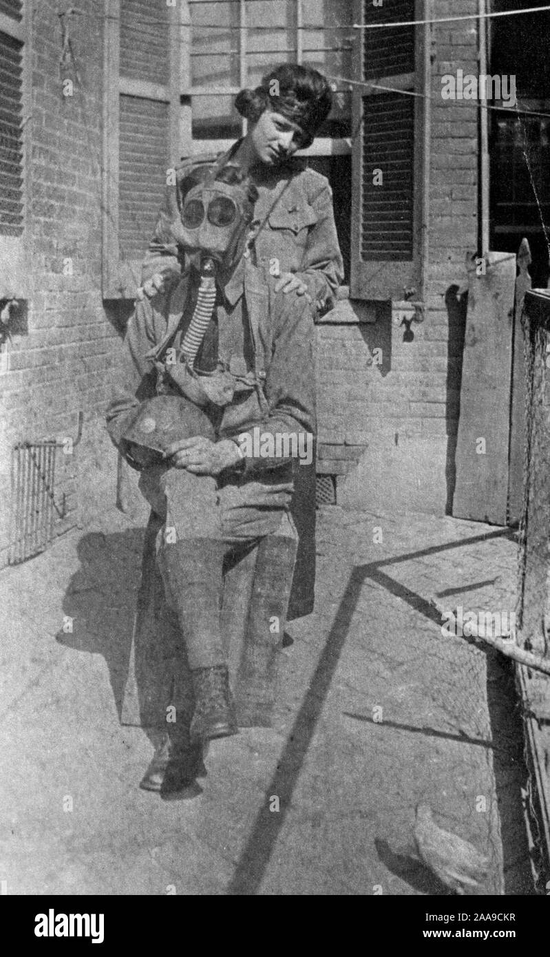 Una giovane donna si distingue per il suo gas-soldato mascherato fidanzato, ca. 1919. Foto Stock