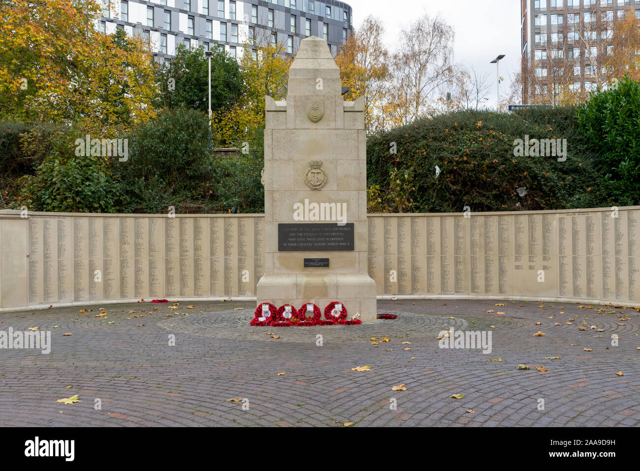 Papavero rosso ghirlande prevista intorno a un memoriale di guerra sul ricordo domenica Foto Stock