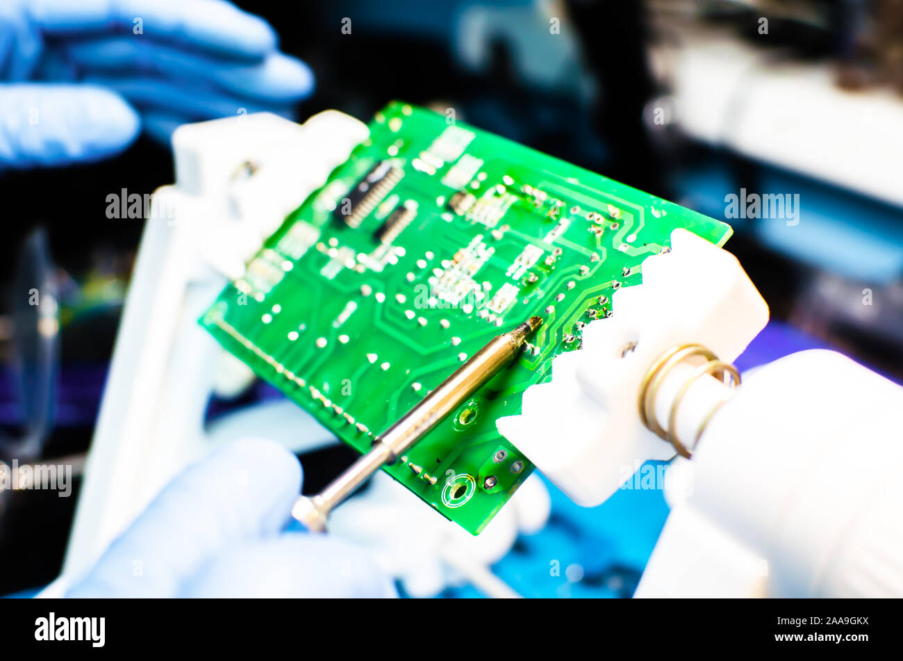 Supporto tecnico lavoratore scende la tassa di PCB. Saldatore. Pinzette a molla Foto Stock