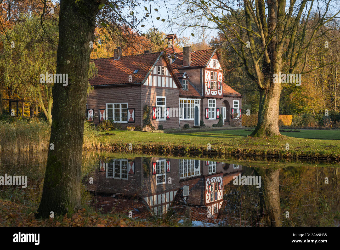 Bellissima casa di campagna con otturatori lungo il canal del castello di Heeze nei Paesi Bassi, riflettendo in acqua Foto Stock