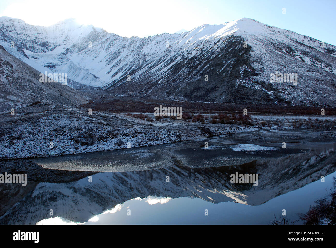 Un piccolo ghiacciaio è riflessa nelle acque di un lago di montagna nelle montagne Daxueshan del Sichuan Foto Stock