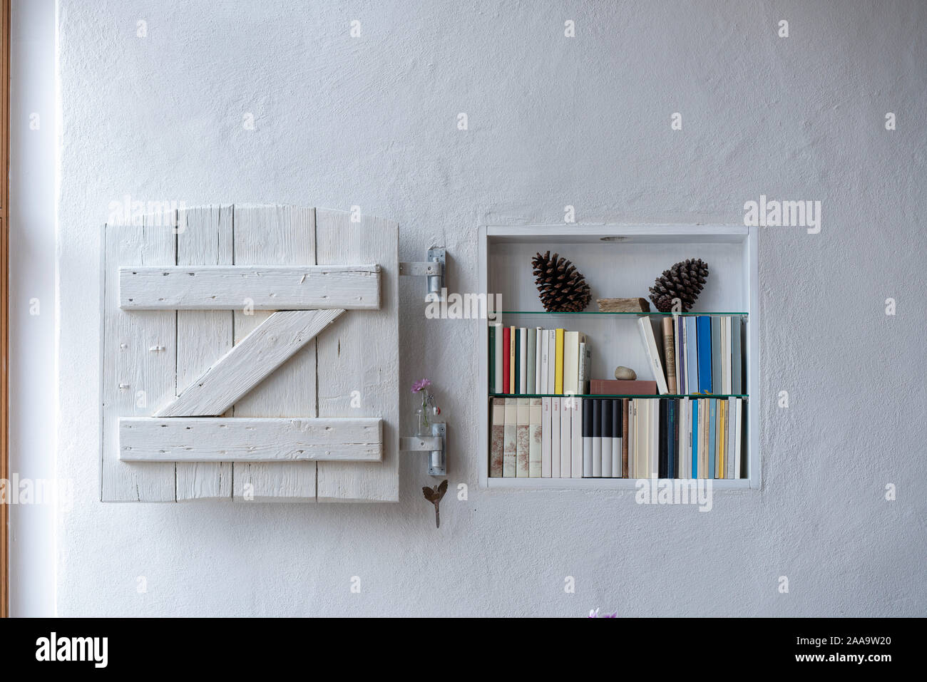 Piccolo scaffale di legno bianco otturatore squallido e decorazione in una parete bianca Foto Stock