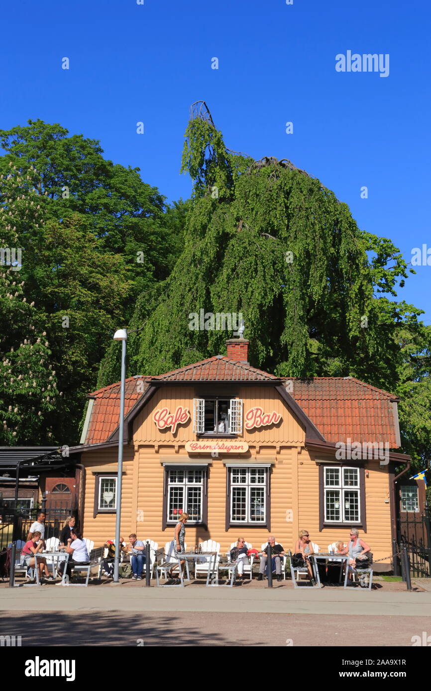 Persone sedersi e godersi rinfreschi nel sole durante la stagione estiva, fuori Grindstugan café e bar a Gothenburg, Svezia. Foto Stock