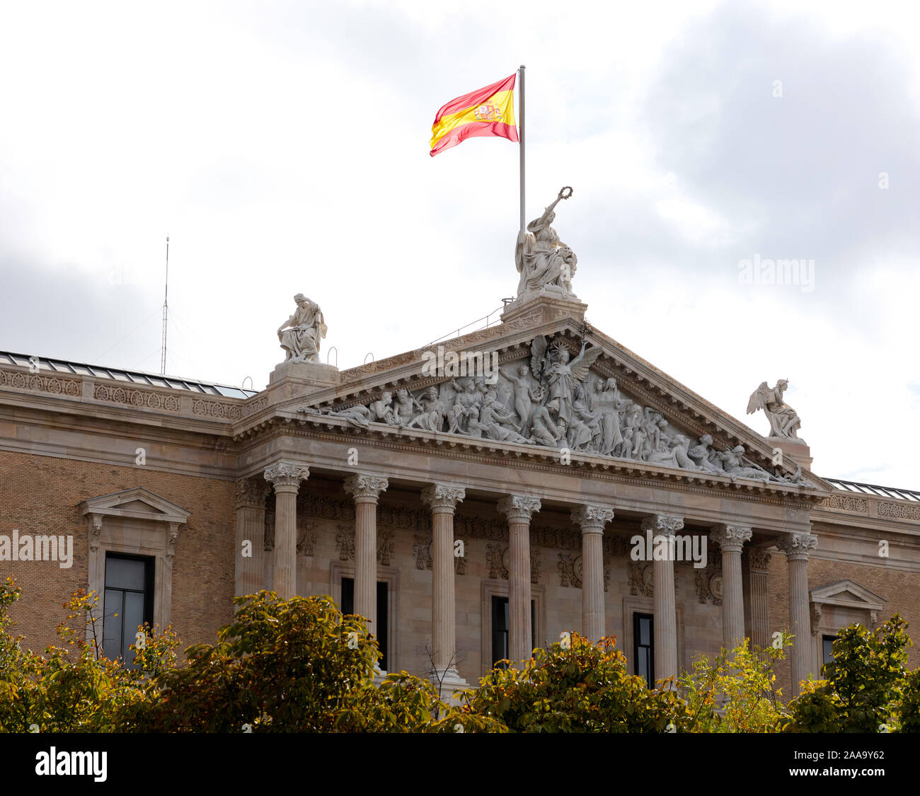 Spanish flag sventolare sopra il portico della Biblioteca Nazionale di Madrid Foto Stock