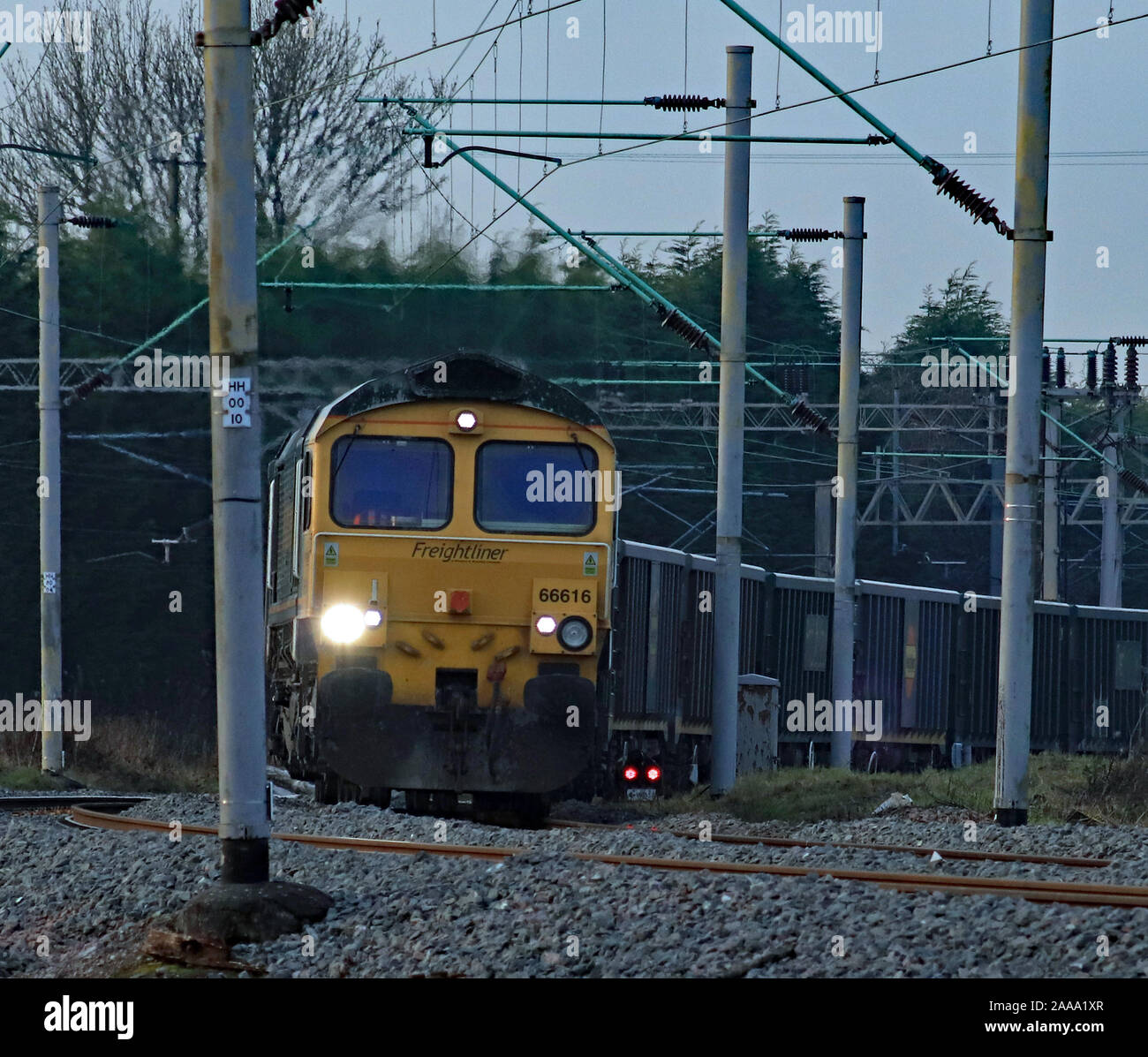 Freightliner locomotiva diesel 66616 giri la curva fuori dalla linea principale della costa occidentale a Hartford giunzione nel Cheshire con un treno di vuoti carri di pietra Foto Stock