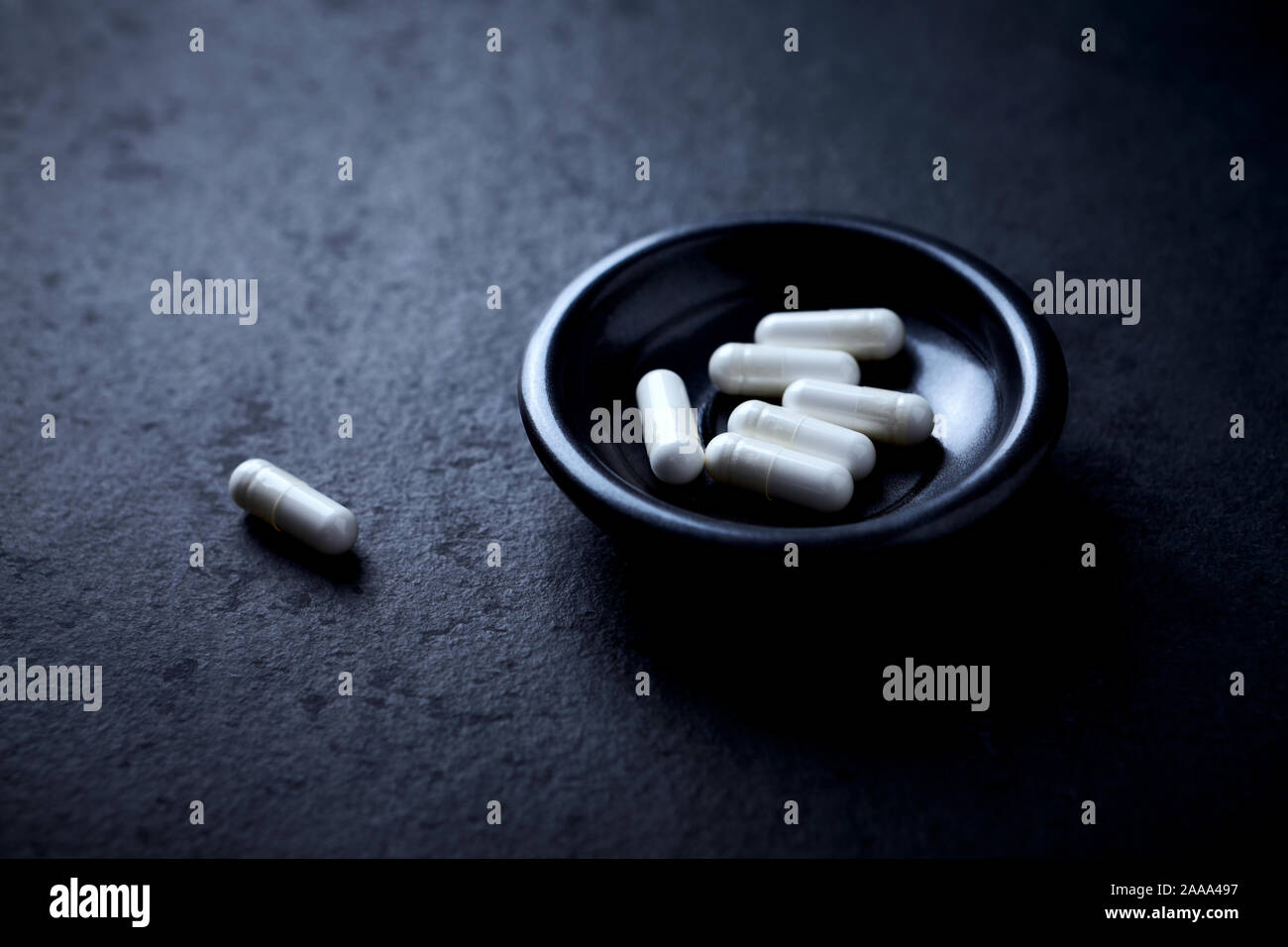 Le capsule di arginina. Bodybuilding integratori alimentari in pietra scura sullo sfondo. Close up. Foto Stock