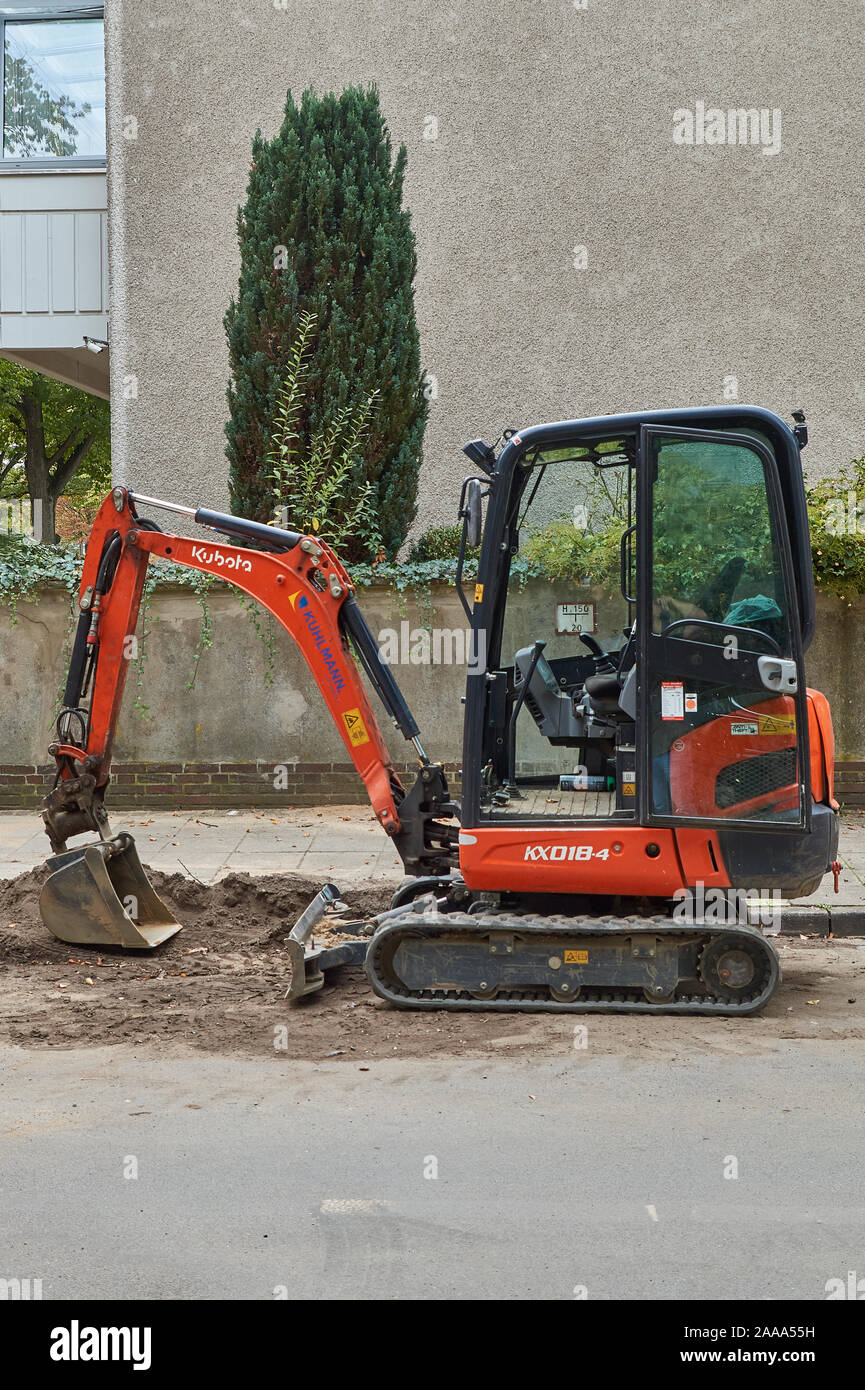 Mini escavatore su una strada di città Foto Stock