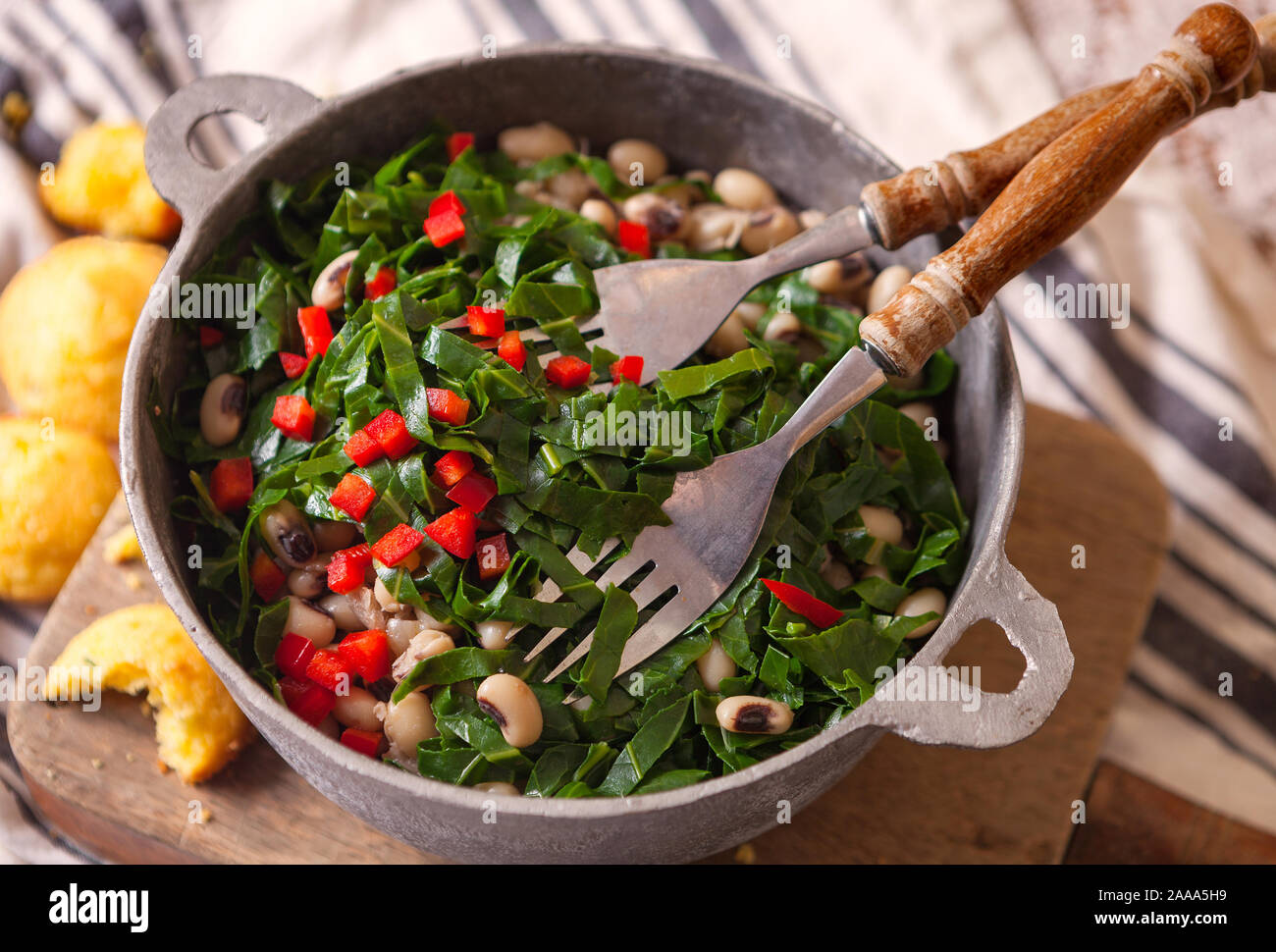 Stati Uniti del sud piatto di black eyed peas, fresche collard verdi e tagliate a dadini il peperone rosso con il pane di mais Foto Stock