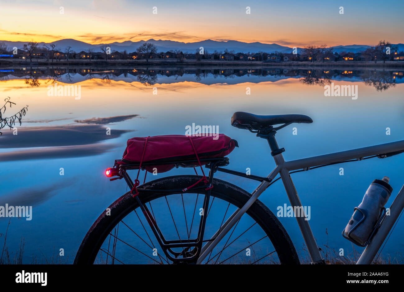 Silhouette di una touring bike contro il tramonto su montagne rocciose e il lago in Loveland, Colorado Foto Stock