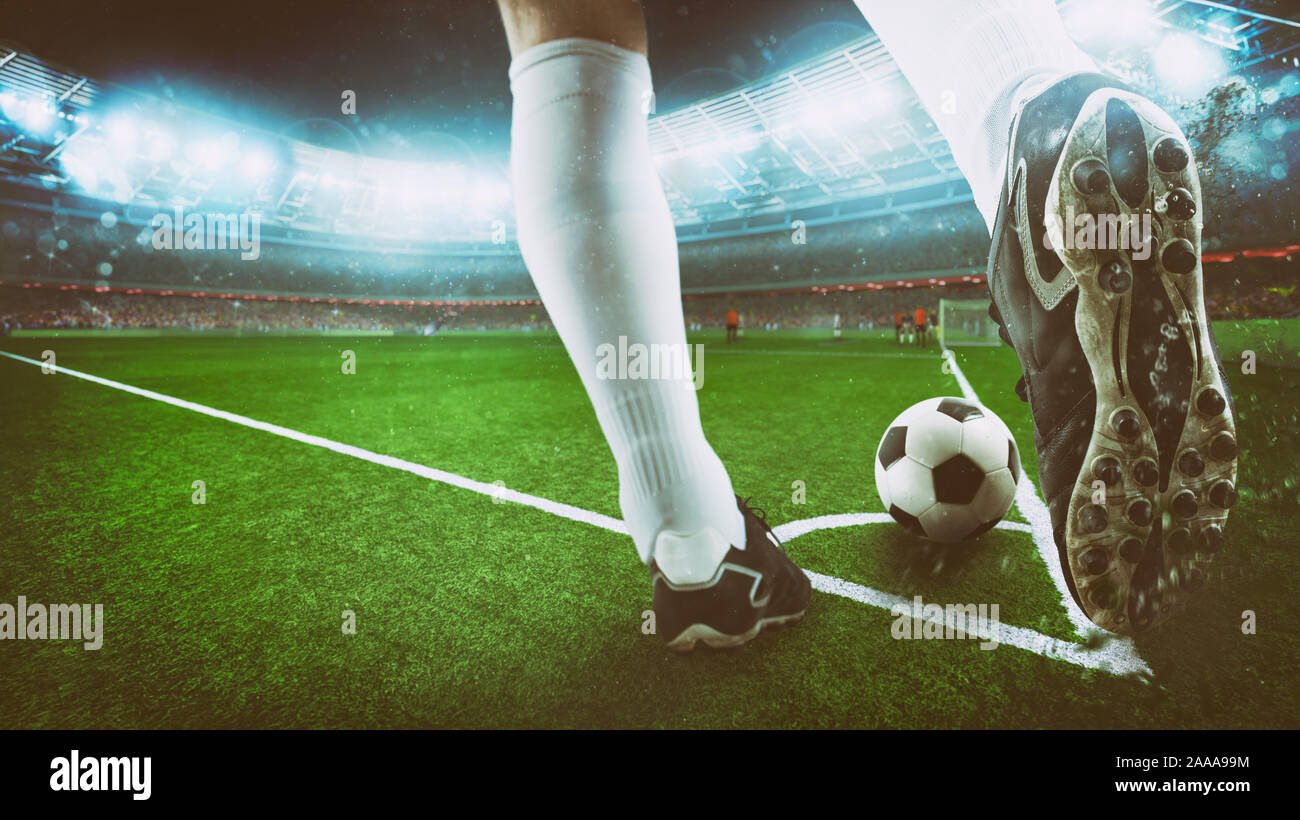 Il calcio di scena a notte corrispondono con close up di una scarpa da calcio di colpire la palla da calcio d'angolo Foto Stock