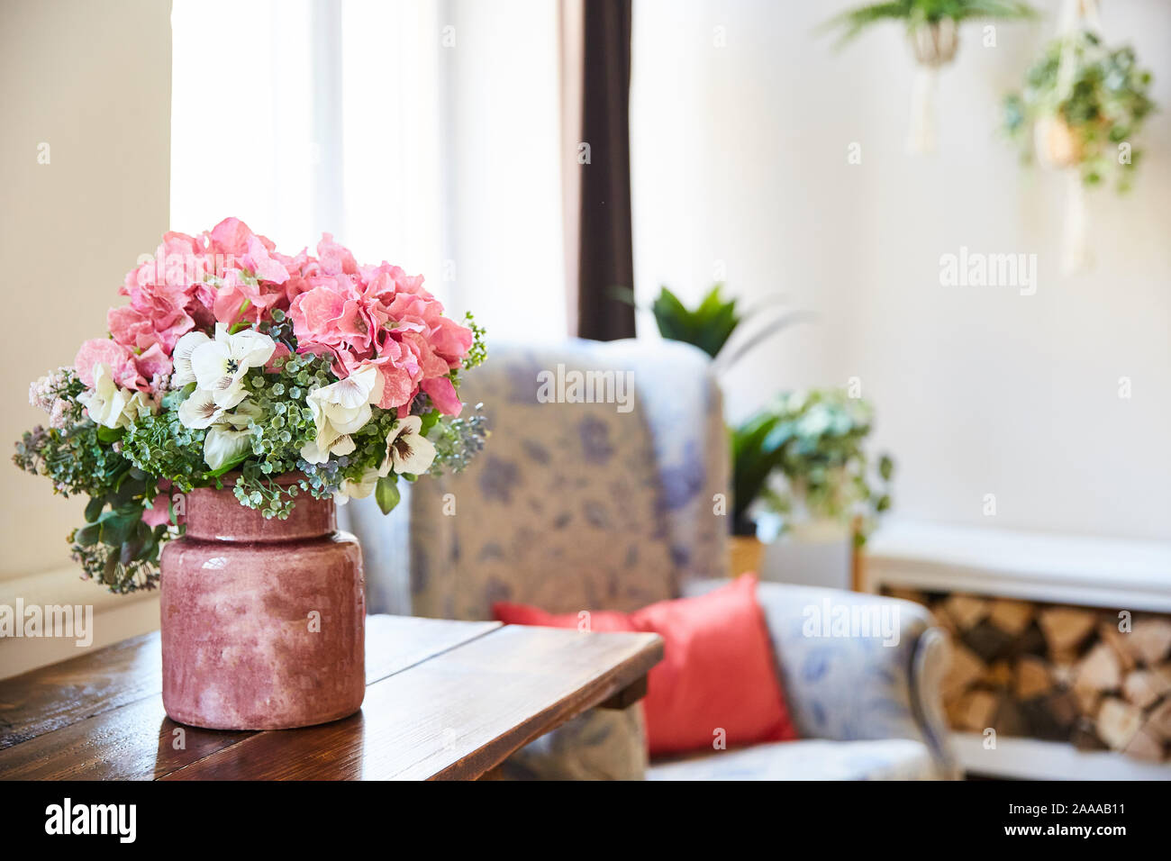 Un mazzo di fiori in un vaso sul tavolo in camera. shabby chic stile Foto Stock