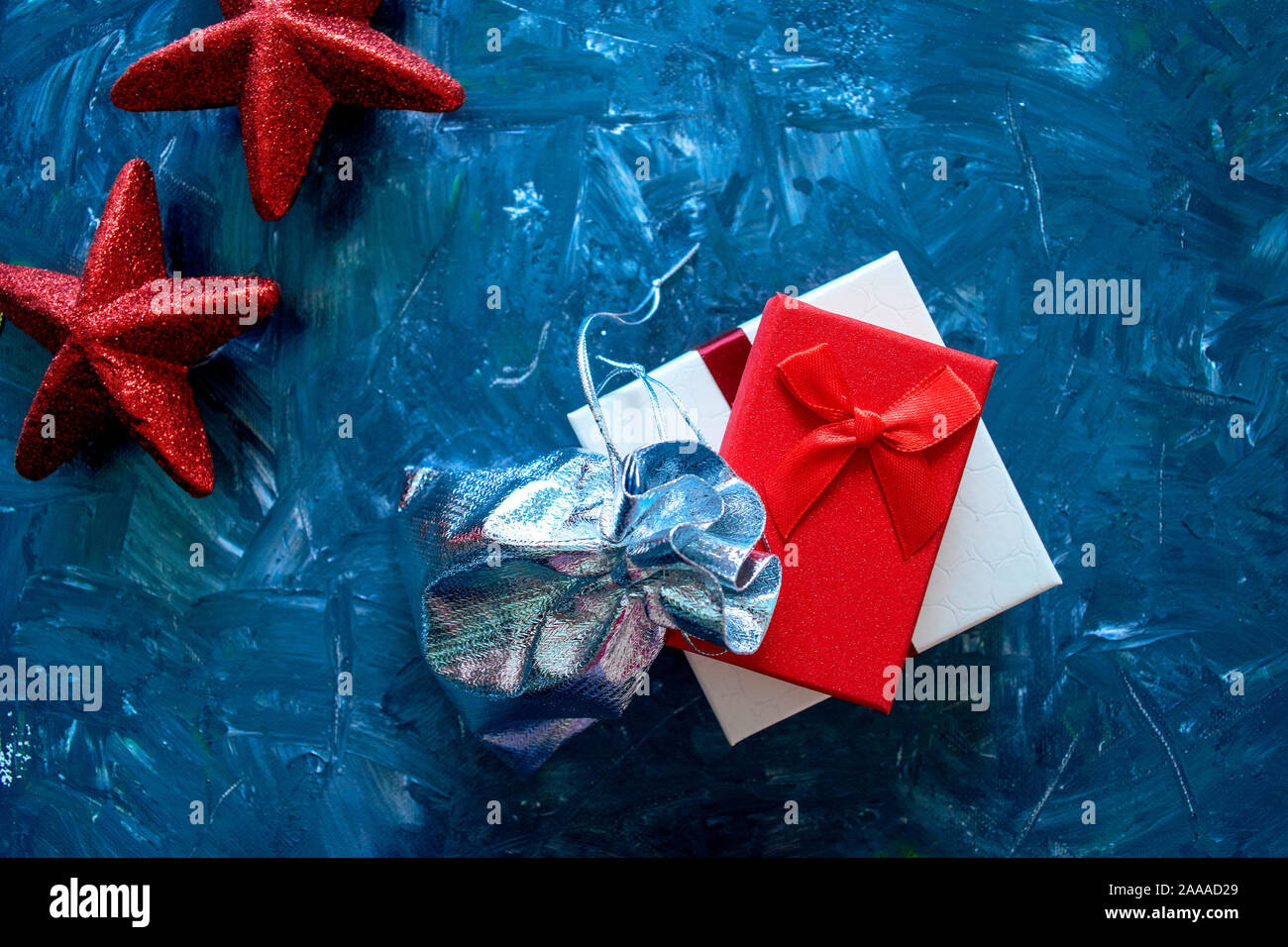 Presente di scatole con stelle rosse su sfondo grigio. Concetto di vacanza. Auguri di Buon Natale e Anno Nuovo sfondo Foto Stock