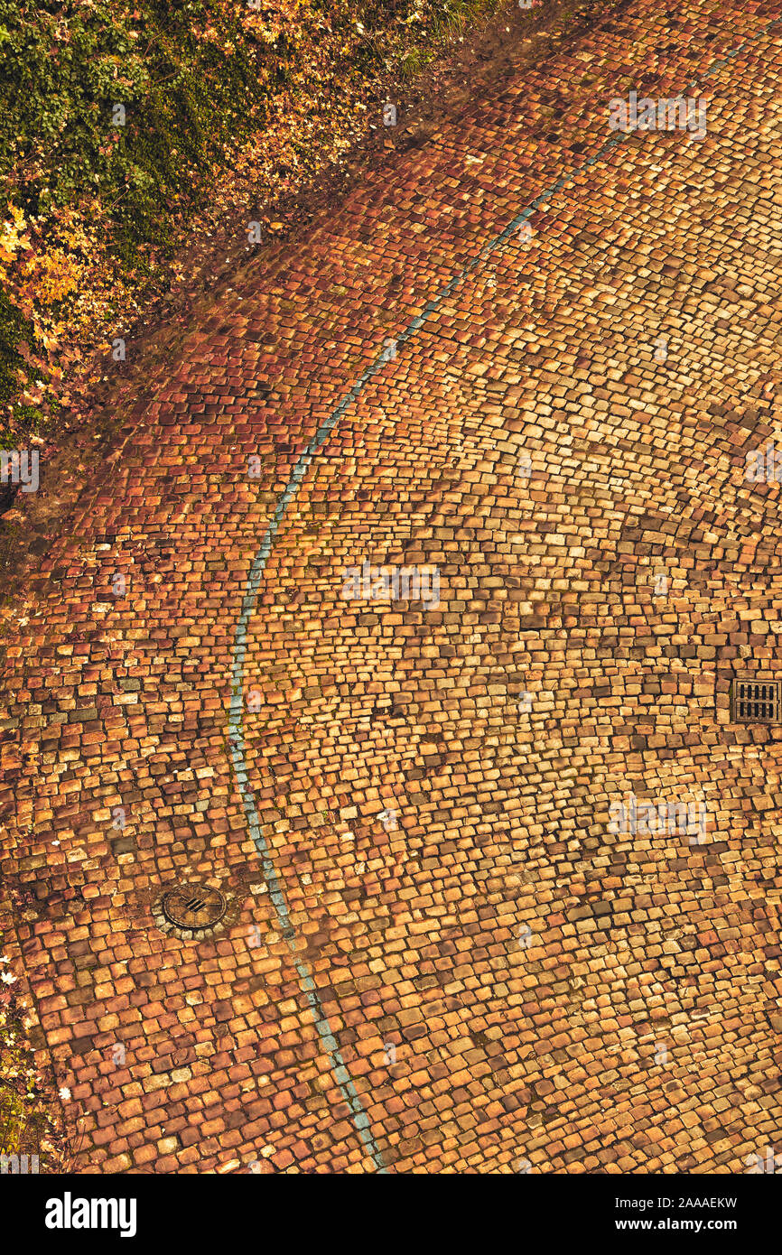 Piegatura nel vecchio arrugginito-marrone pavimentazione di pietra sulla strada di una giornata piovosa / autunno nel Castello di Vyšehrad, Praga Foto Stock