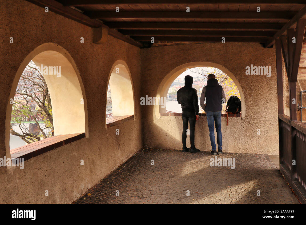 Due uomini / amici godendo di vista dal porticato finestrato rifugio storico / gazebo / belvedere nelle mura di fortificazione del Castello di Vyšehrad, Praga Foto Stock