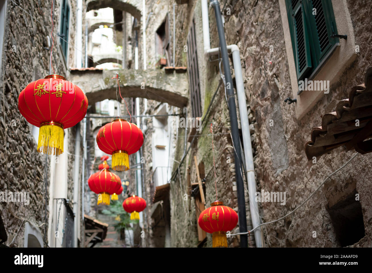 Colorata di rosso e di giallo le lanterne cinesi decorare uno stretto  vicolo nel borgo medioevale di Dolceacqua sulla costa ligure dell'Italia  Foto stock - Alamy