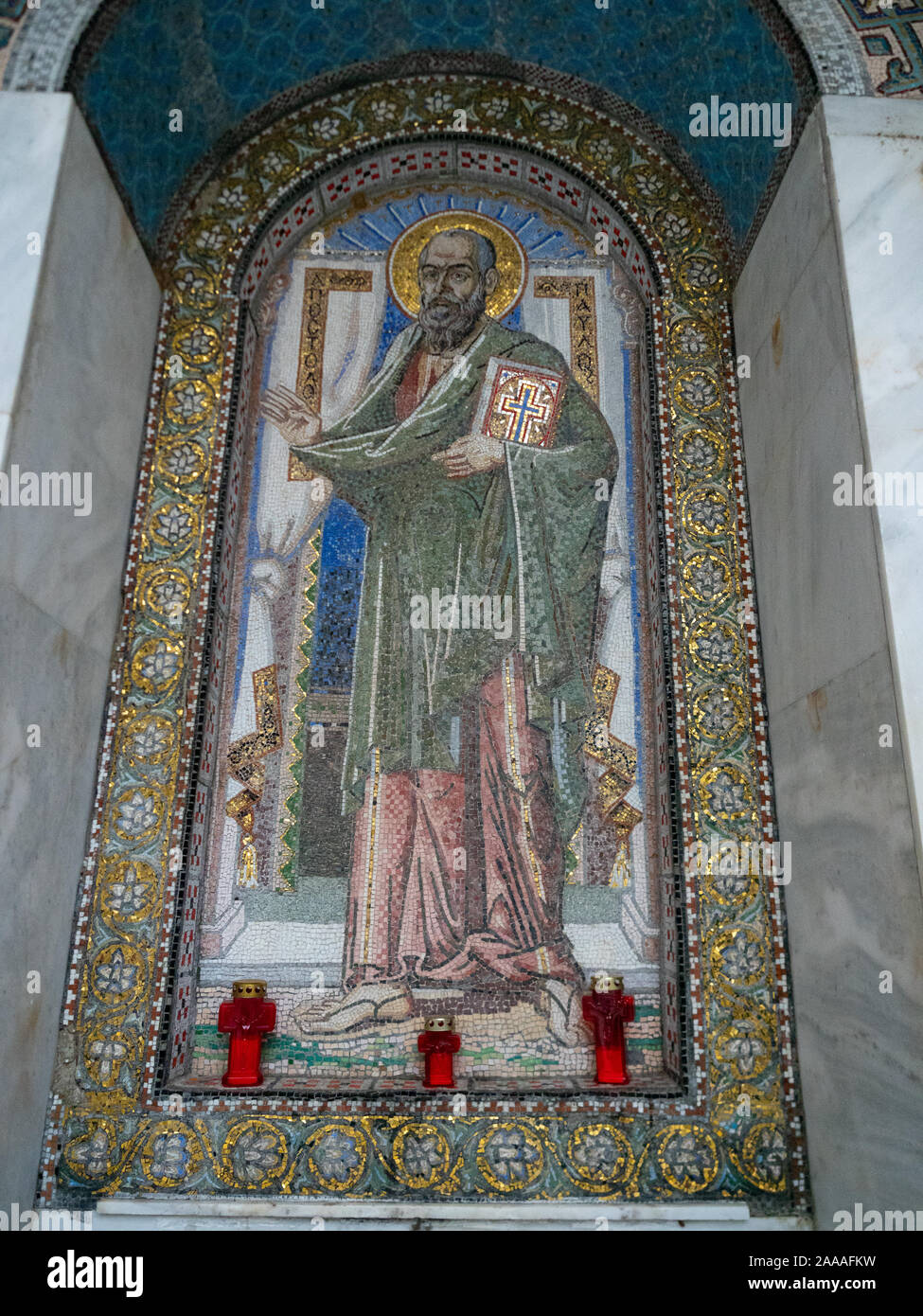 Mosaico di San Paolo con una bibbia con il rosso a forma di croce candele ai piedi del mosaico e una decorazione design floreale con accenti d'oro. Foto Stock