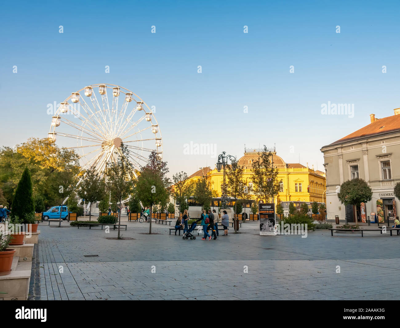 SZEKESFEHERVAR, Ungheria - 26 ottobre 2019: vista sulla ruota panoramica Ferris in Zichy park e la gente che camminava per le strade di Szekesfehervar, Ungheria su Foto Stock