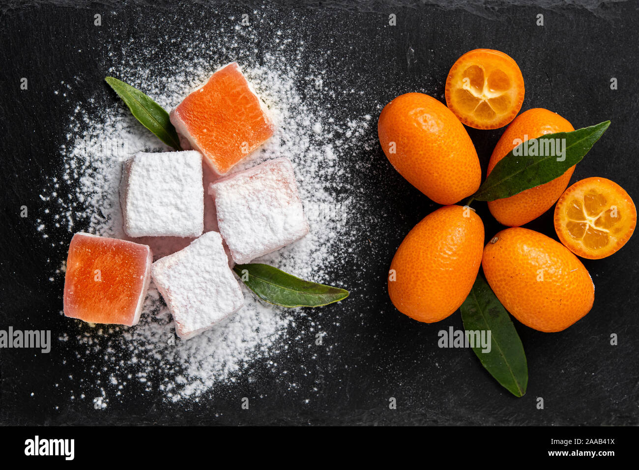 Le delizie turche con kumquat sapore su una pietra scura Foto Stock