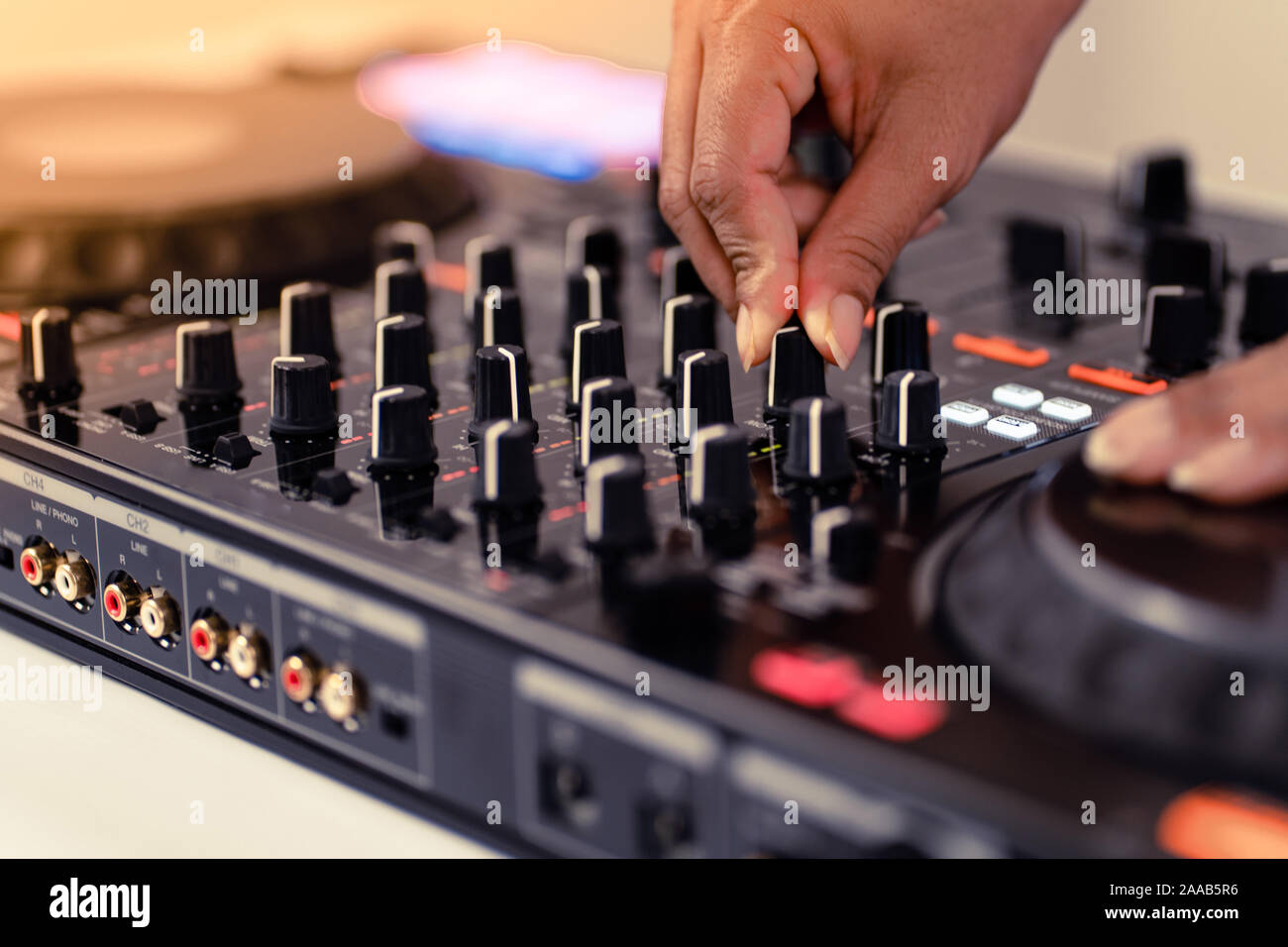 Le mani di DJ mixare brani su professional mixer audio.gli anelli alla moda sulle dita di una ragazza disc jockey riproduzione di musica.Closeup,le manopole e i regolatori di Foto Stock