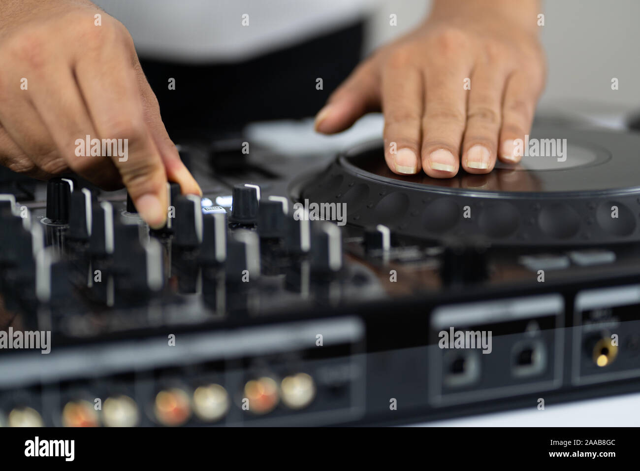 Le mani di DJ mixare brani su professional mixer audio.gli anelli alla moda sulle dita di una ragazza disc jockey riproduzione di musica.Closeup,le manopole e i regolatori di Foto Stock
