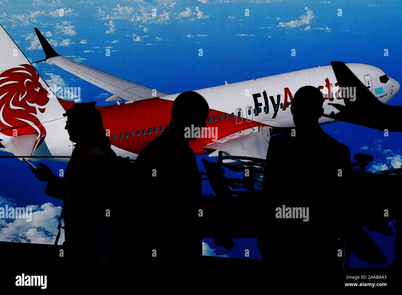 Dubai, Emirati Arabi Uniti. Xix Nov, 2019. Visitatori stand accanto all'immagine di un kazaco compagnia aerea a basso costo volare Airstan Boeing-737 MAX 8, durante il terzo giorno del Dubai International-2019 Airshow. Credito: SOPA Immagini limitata/Alamy Live News Foto Stock