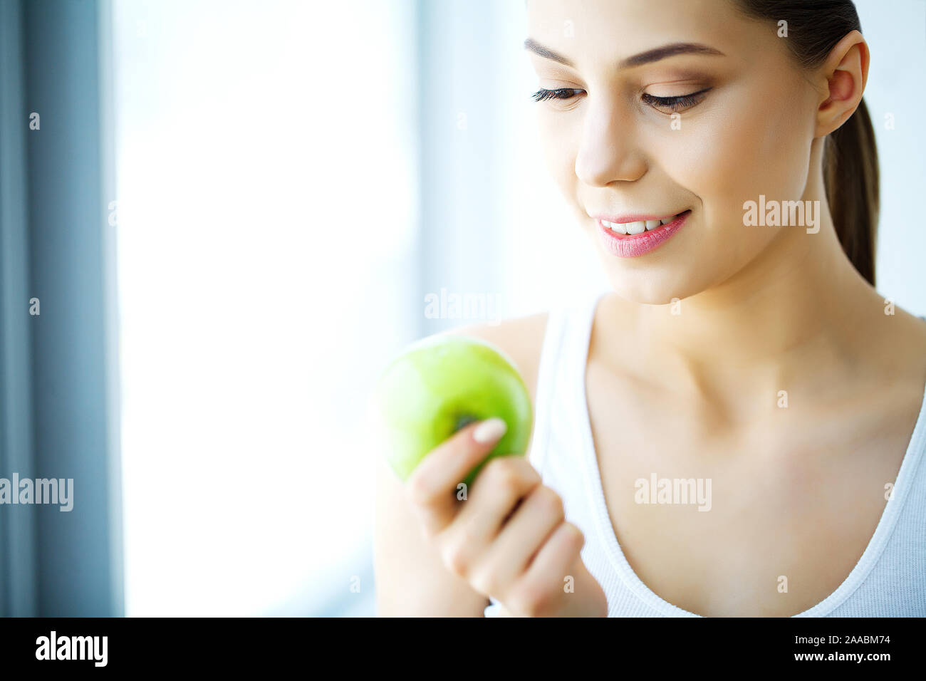 Donna sorridente con bel sorriso, denti bianchi azienda Apple. Immagine ad alta risoluzione Foto Stock