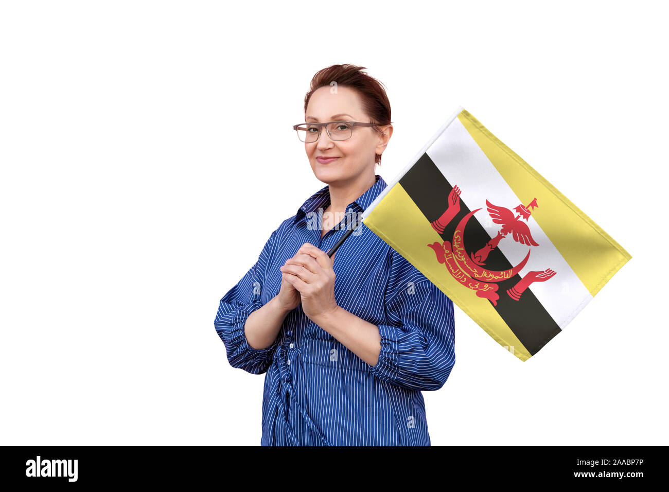 Bandiera del Brunei. Donna che mantiene il Brunei bandiera. Bel ritratto di mezza età lady 40 50 anni tenendo un grande bandiera isolati su sfondo bianco. Foto Stock