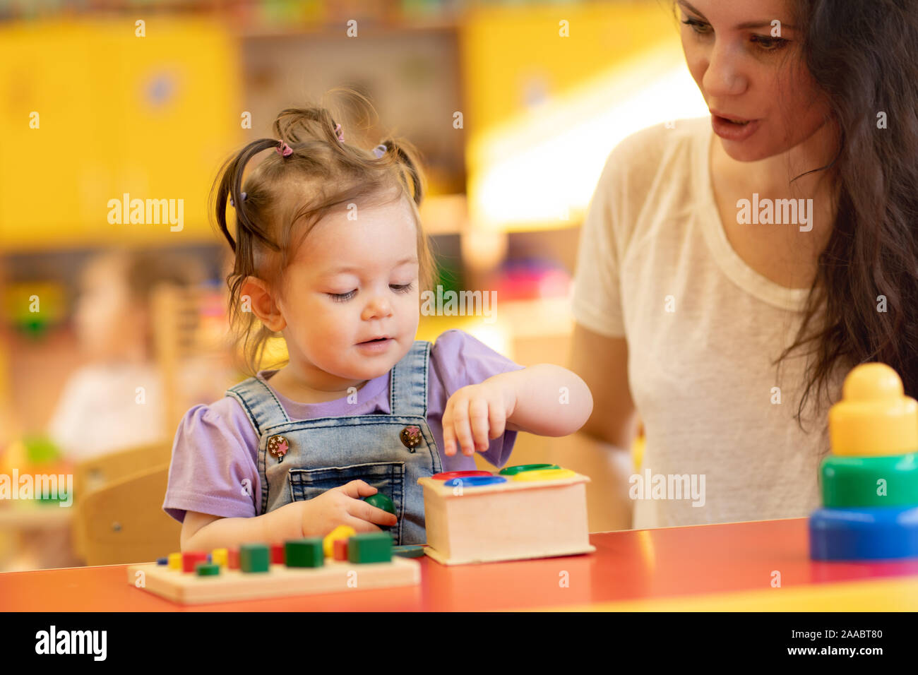 Genitore e bambino gioca con giocattoli educativi, impilatura e disponendo i pezzi colorati. Apprendimento tramite esperienza concept Foto Stock