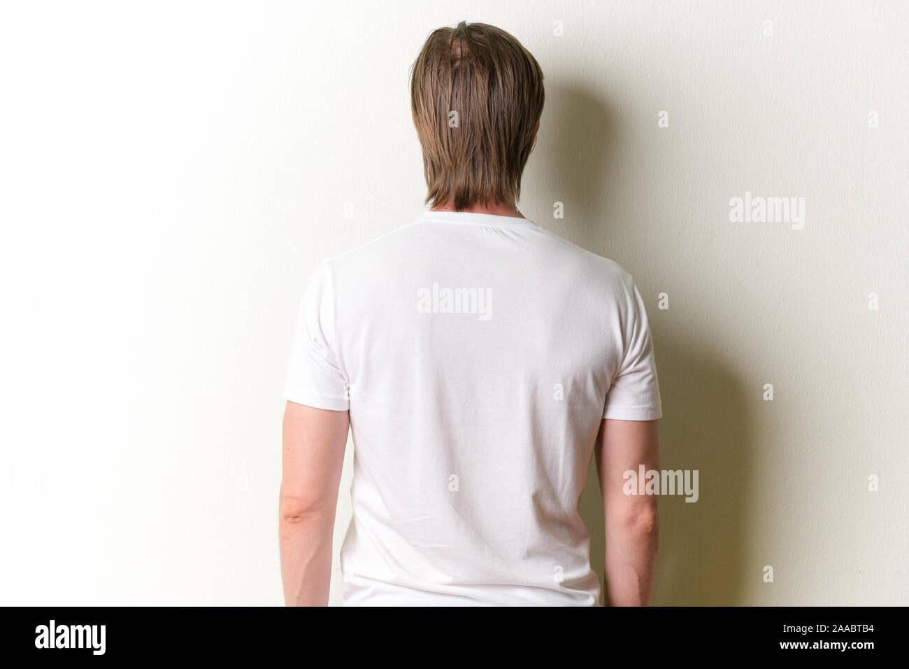 Vista posteriore del giovane uomo con lunghi capelli biondi Foto Stock