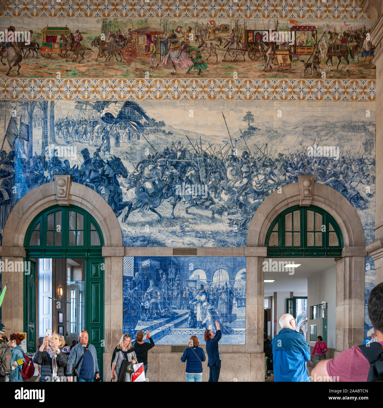 Ceramiche dipinte tileworks (azulejos) sulle pareti interne della sala principale di alla Stazione Ferroviaria di Sao Bento a Porto, Portogallo Foto Stock