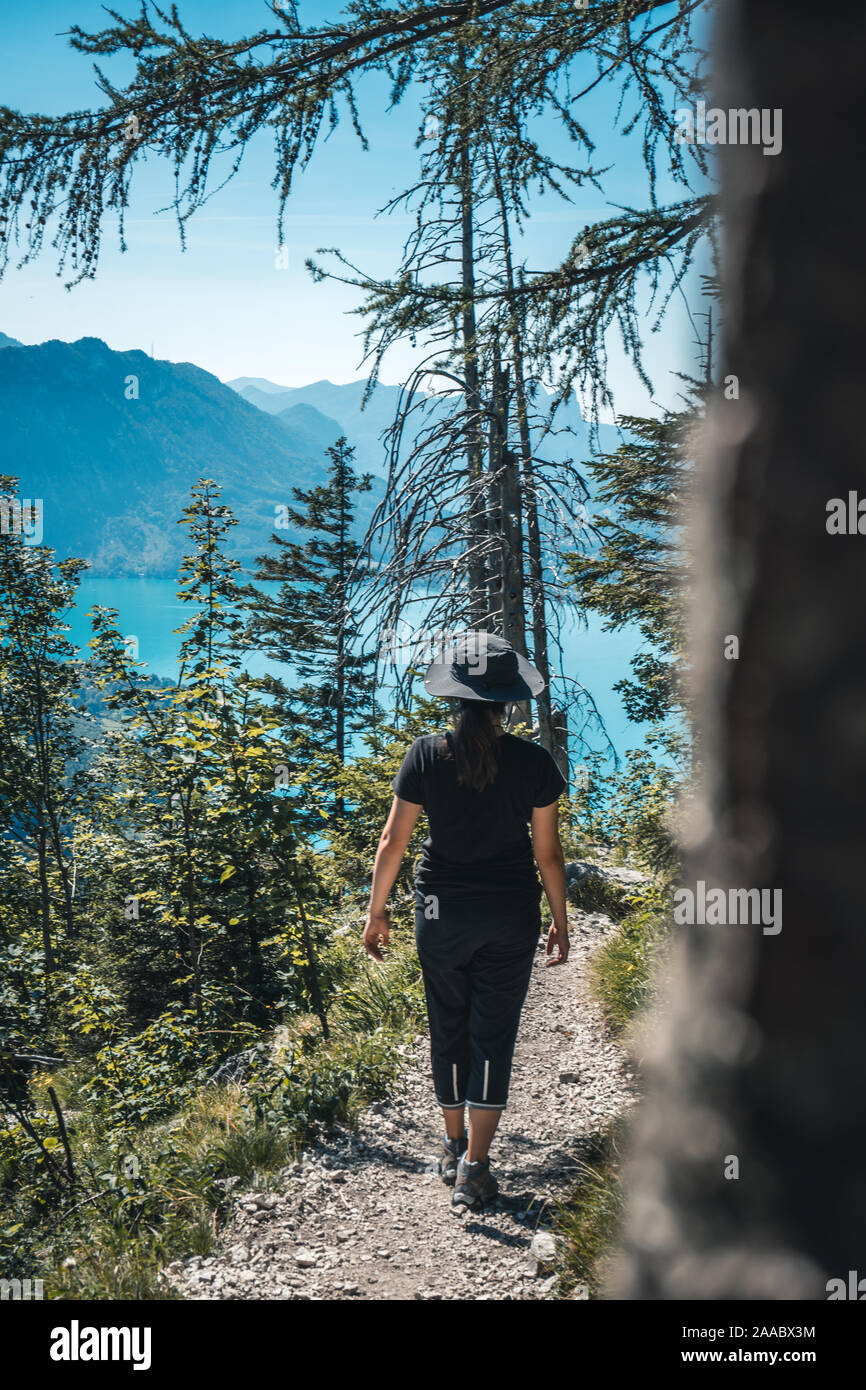 Ragazza con un cappello arrampicata, escursioni verso il basso dal monte Schoberstein e guardando giù per il lago ateria (Attersee) nelle Alpi, Austria Foto Stock