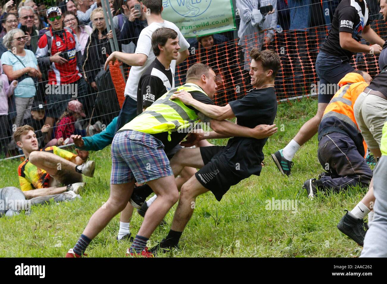 Il primo mens in discesa gara runner di essere catturati in fondo alla collina. La laminazione di formaggio follia e divertimento su Cooper's Hill, Gloucester. 27/05/201 Foto Stock